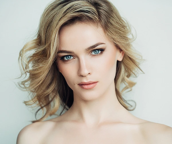 A young woman with blue eyes and blonde hair, showcasing her skin after Fractional CO2 Laser Treatment.