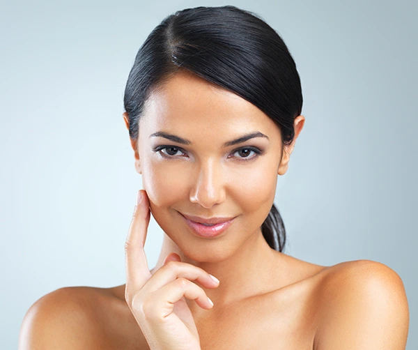 A smiling woman with a clear complexion, showcasing the results of Fractional CO2 Laser Treatment.